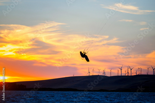 USA, California, Rio Vista, Sacramento River Delta. Kiteboarder catching air at sunset.