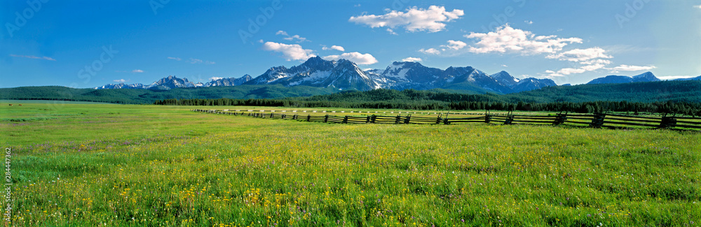 USA, Idaho, Sawtooth NRA. A split-rail fence extends to the Sawtooth Range at Sawtooth NRA, Idaho. - obrazy, fototapety, plakaty 