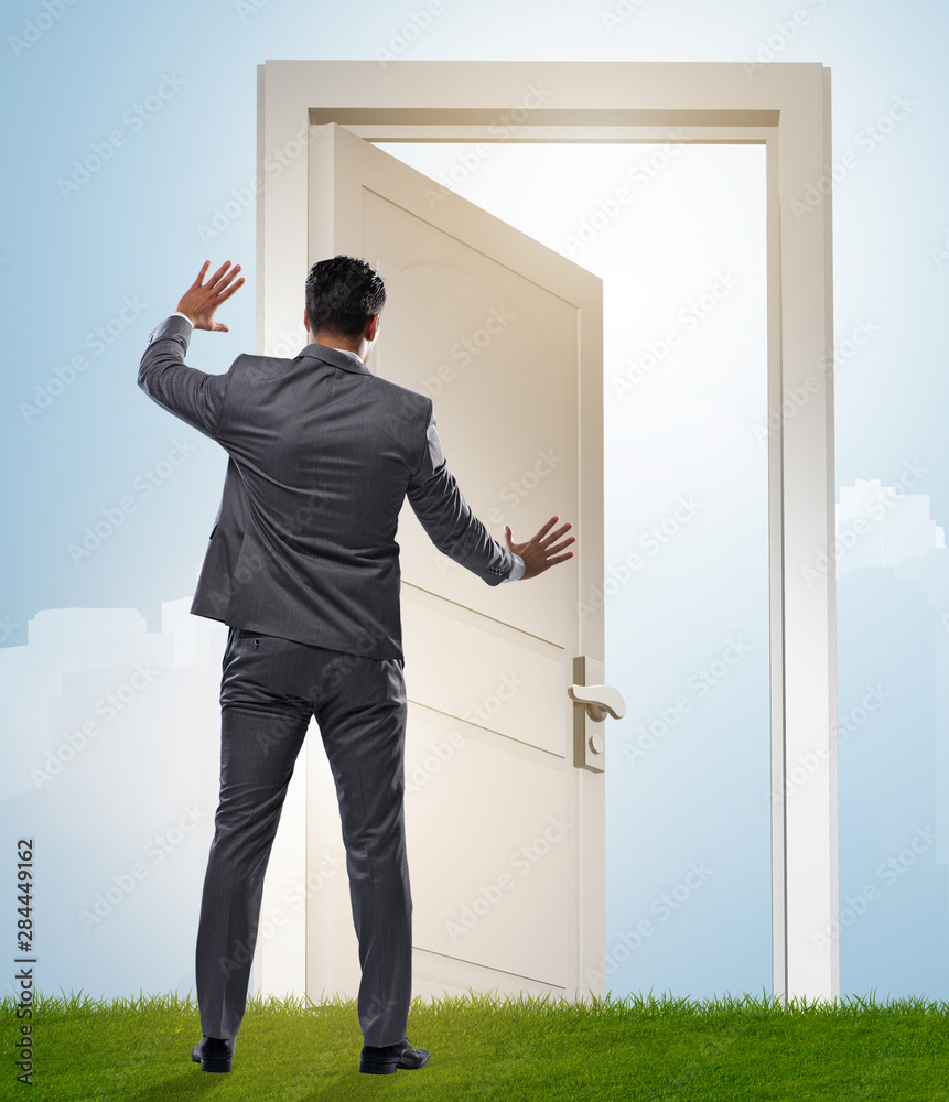 Businessman standing in front of door into future Businessman standing in front of door into future