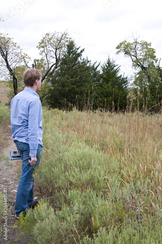 United States, Kansas. A visitor to the Tallgrass Prairie National Preserve views the native grasses.