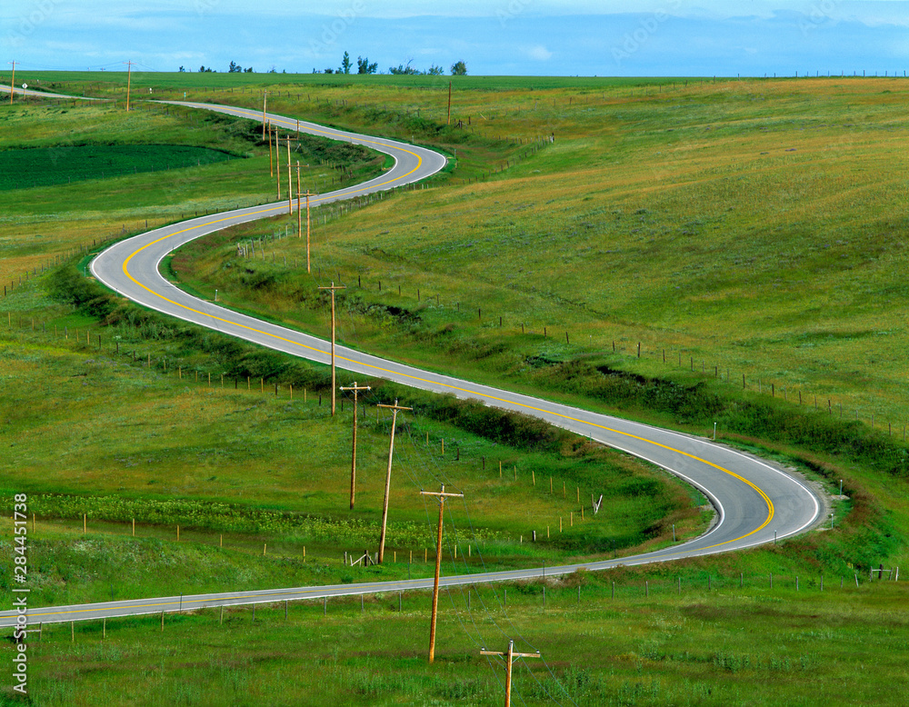 USA, Montana, Browning. A rural highway snakes over the countryside near Browning, Montana.