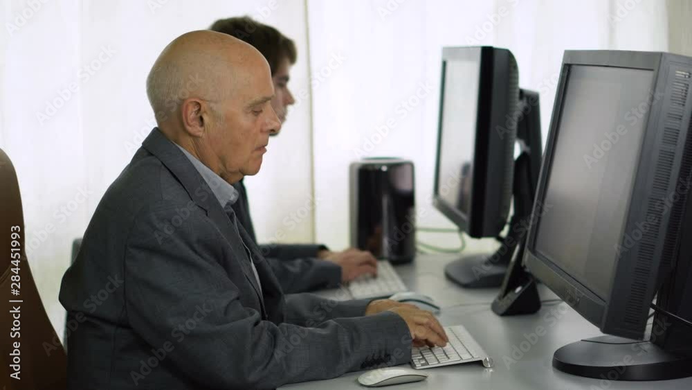 Businessman in Suit Typing on Desktop Computer in Office Businessman in Suit Typing on Desktop Computer in Office