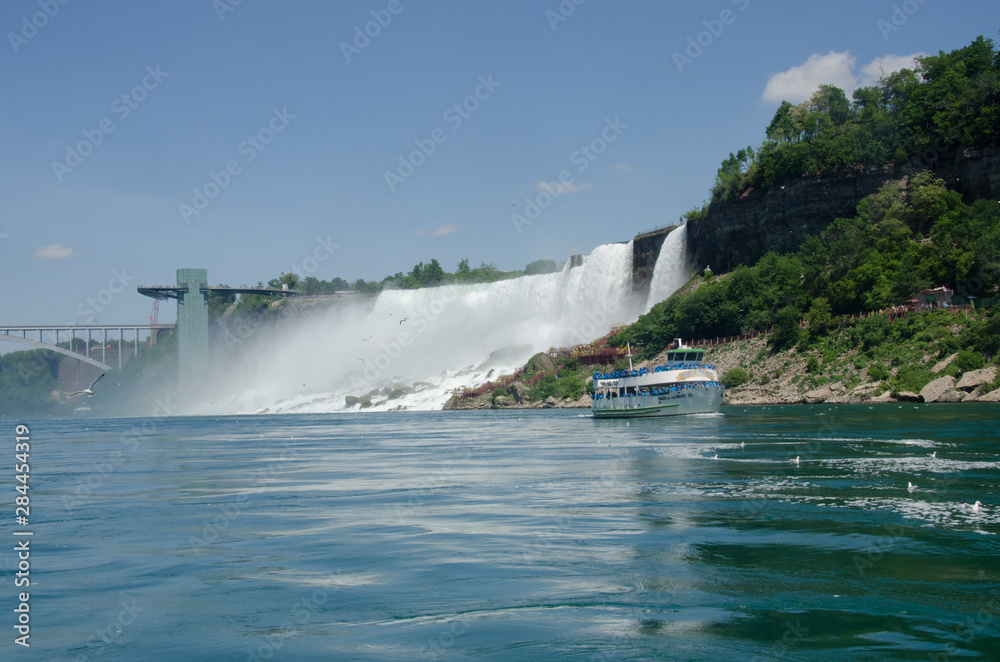 USA, New York, and Canada, Ontario, Niagara Falls. USA side, view of American Falls with Maid of the Mist tourist boat. USA, New York, and Canada, Ontario, Niagara Falls. USA side, view of American Falls with Maid of the Mist tourist boat.