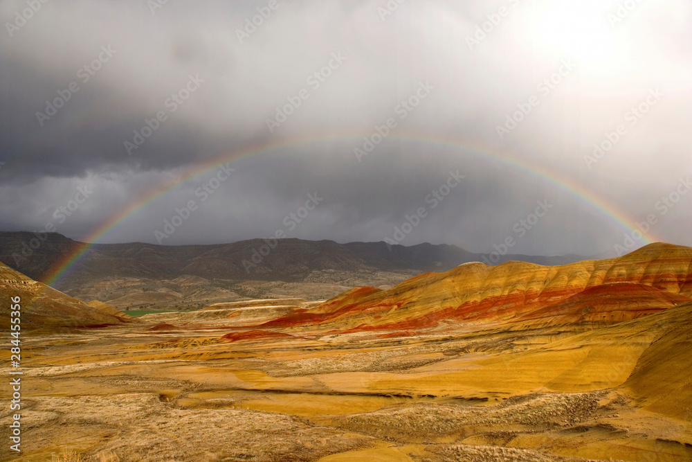 USA, Oregon, John Day Fossil Beds National Monument. Scenic of rainbow over the Painted Hills and storm clouds. 
