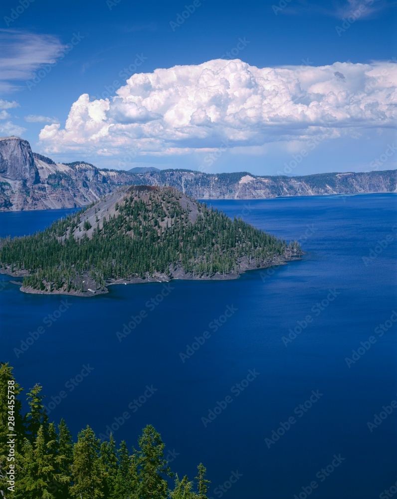 USA, Oregon, Crater Lake National Park. Thunder clouds float over Wizard Island and Crater Lake.