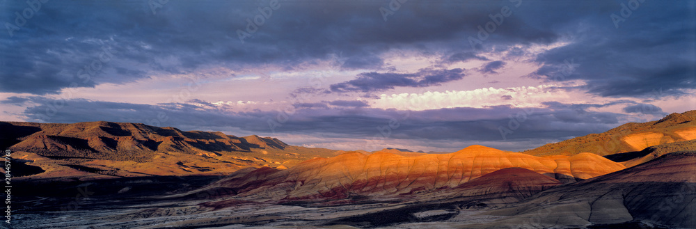 USA, Oregon, John Day Fossil Beds NM. Sunset light castes long shadows at the Painted Hills section of John Day Fossil Beds NM, Oregon.