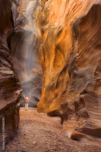 USA, Utah, Willis Creek. Woman hiker admiring slot canyon rock formations. 