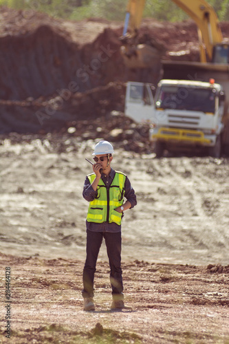 Portrait of asian male supervisor in mine soil field location operation a radio or walkie talkie