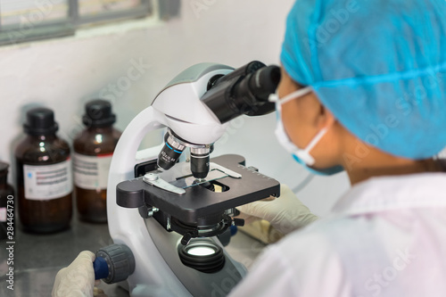 Asian technician tests the quality of product in laboratory closeup