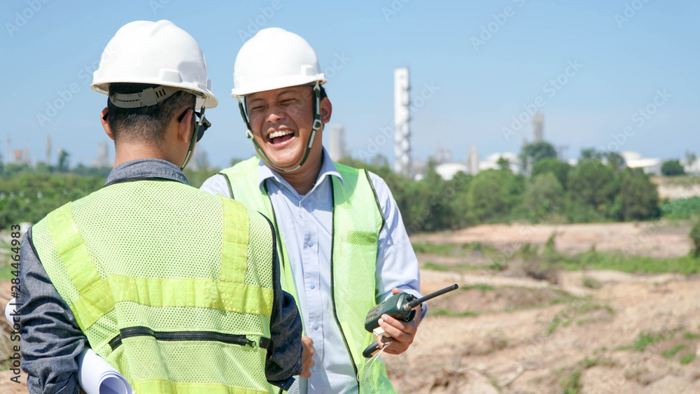 portrait of two engineer's or architect's dress with hardhat, safety helmet and safety vest have a meeting outdoors portrait of two engineer's or architect's dress with hardhat, safety helmet and safety vest have a meeting outdoors