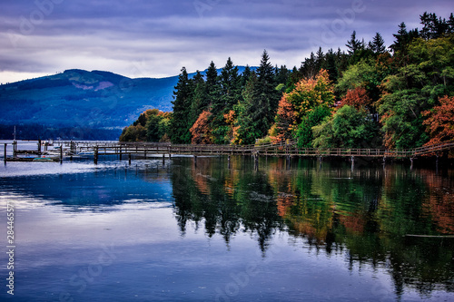 Discovery Bay, Sequim, Washington State. Fall foliage and the trees reflection in the water on Discovery Bay with docks