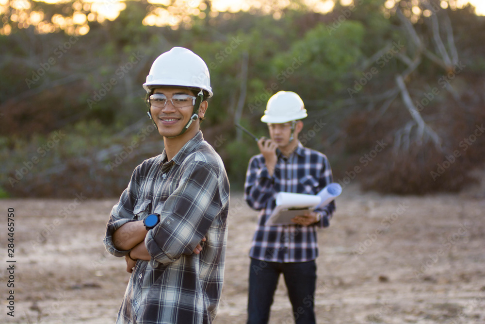 portrait of enginers or architect posed in front of the camera with his workmate as a background portrait of enginers or architect posed in front of the camera with his workmate as a background