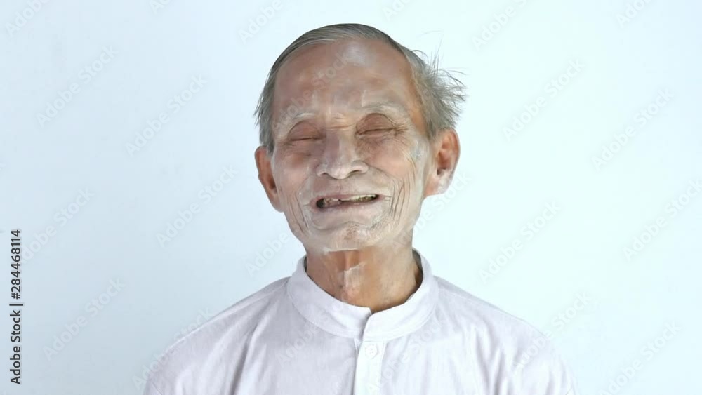 Cheerful of Asian senior man pour the talcum to hand and apply on his face and neck. Cheerful of Asian senior man pour the talcum to hand and apply on his face and neck.