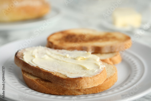 Tasty bread with butter on plate, closeup
