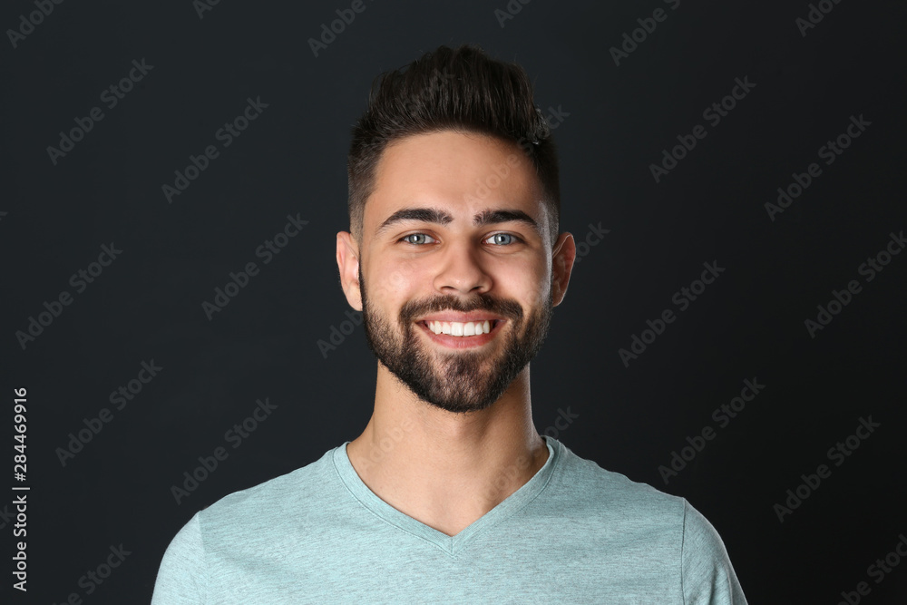 Fototapeta premium Portrait of handsome smiling man on black background