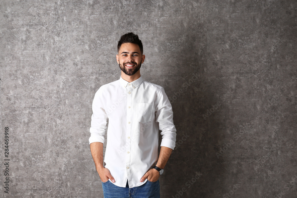 Portrait of handsome smiling man on grey background. Space for text