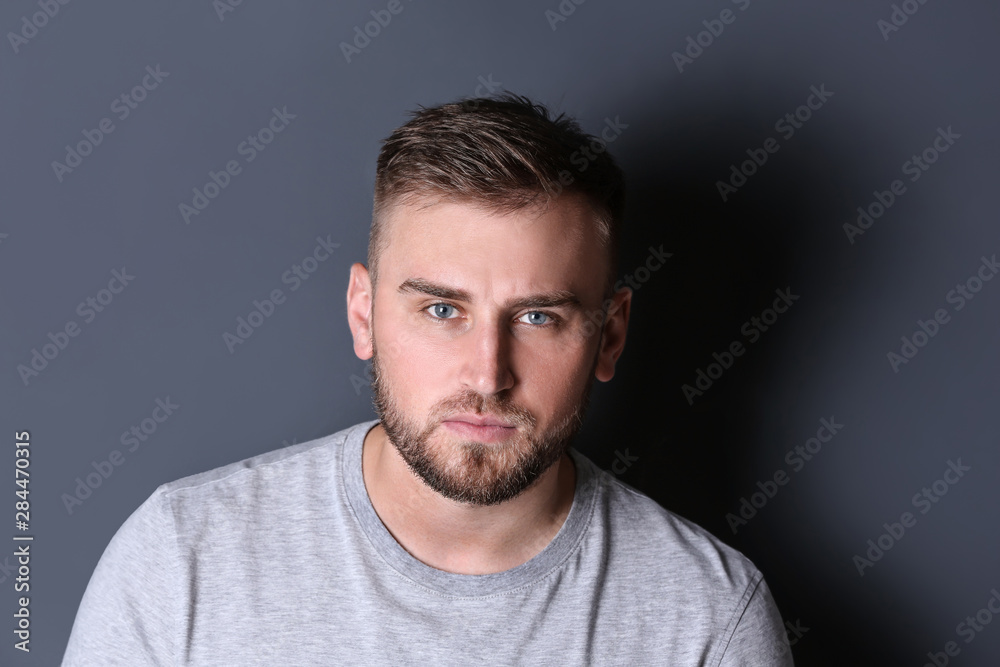 Portrait of handsome serious man on grey background
