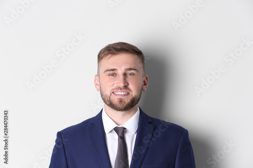 Portrait of happy man in office suit on white background