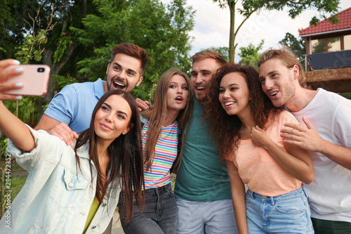 Happy young people taking selfie in park