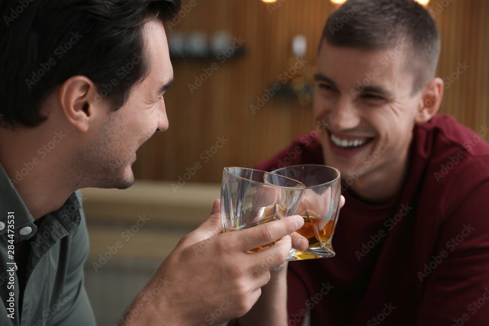 Young men drinking whiskey together in bar Young men drinking whiskey together in bar