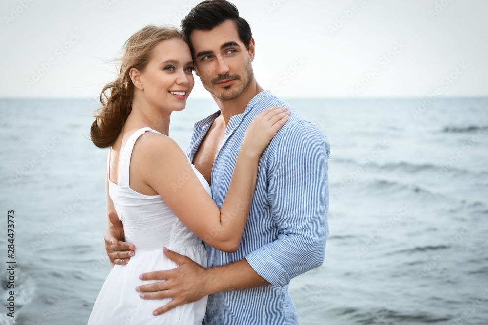 Happy young couple spending time at sea beach Happy young couple spending time at sea beach