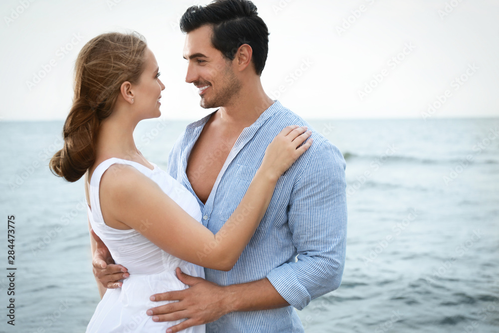 Happy young couple spending time at sea beach Happy young couple spending time at sea beach