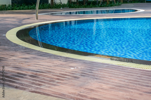 Blue swimming pool with wood flooring stripes © Hanoi Photography