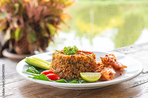 Fried rice with Shrimp on wooden table , spicy food Thai style Background rivers and trees.