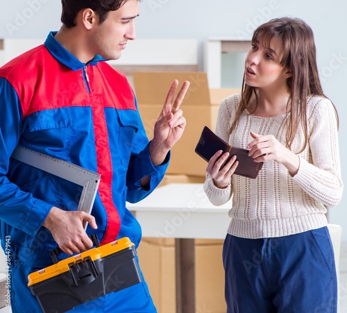 Contractor repairman assembling furniture under woman supervisio photo