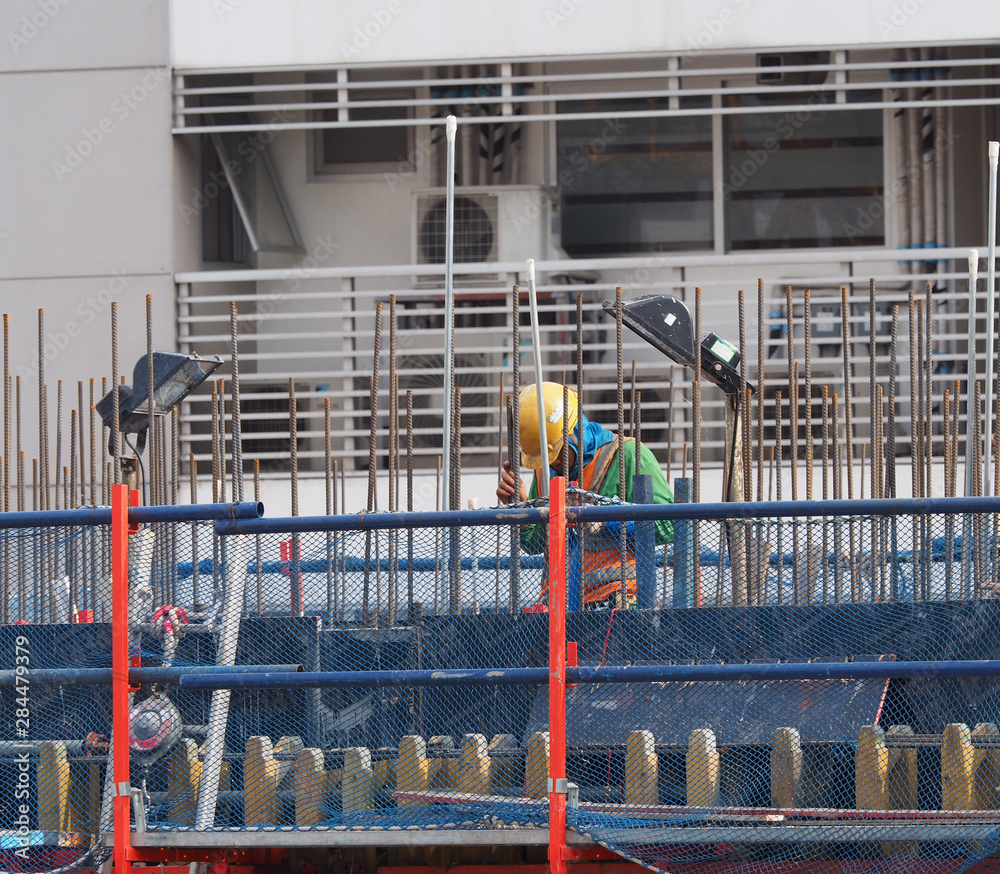 a worker is working on high contruction area, with iron wire structure