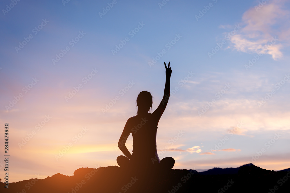 silhouette woman sitting and fighting  movitation feeling on top of mountain