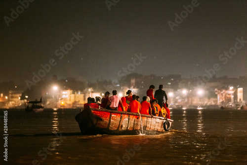 Diversity of people in the boat floating on the river are going to pray at Varanasi Ganga Aarti at holy Dasaswamedh Ghat, near Kashi Vishwanath Temple, Varanasi, India. photo
