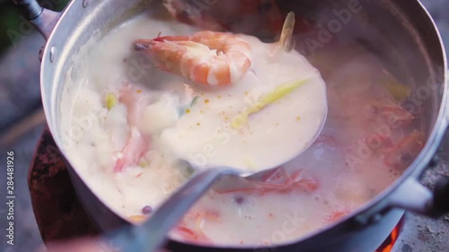 Lady stirring up a pot of River prawn spicy soup. Tom Yam Goong. Traditional Thailand food.