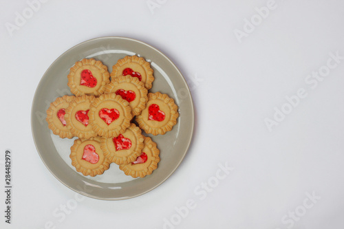 Valentines day heart shaped red jam filled cookies on plate isolated on white .top view.space for text and copy