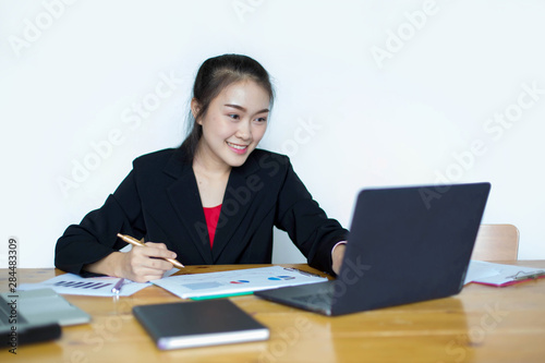 Portrait of Business woman smiles beautiful skin sitting at desk and working with laptop computer.