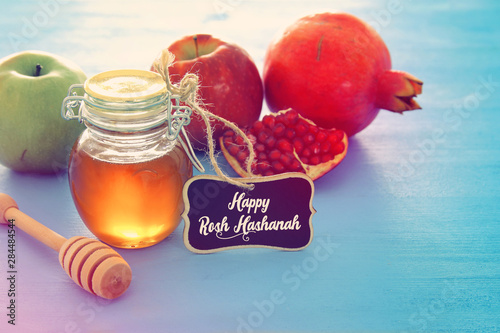 rosh hashanah (jewesh holiday) concept - honey, apple and pomegranate traditional holiday symbols photo