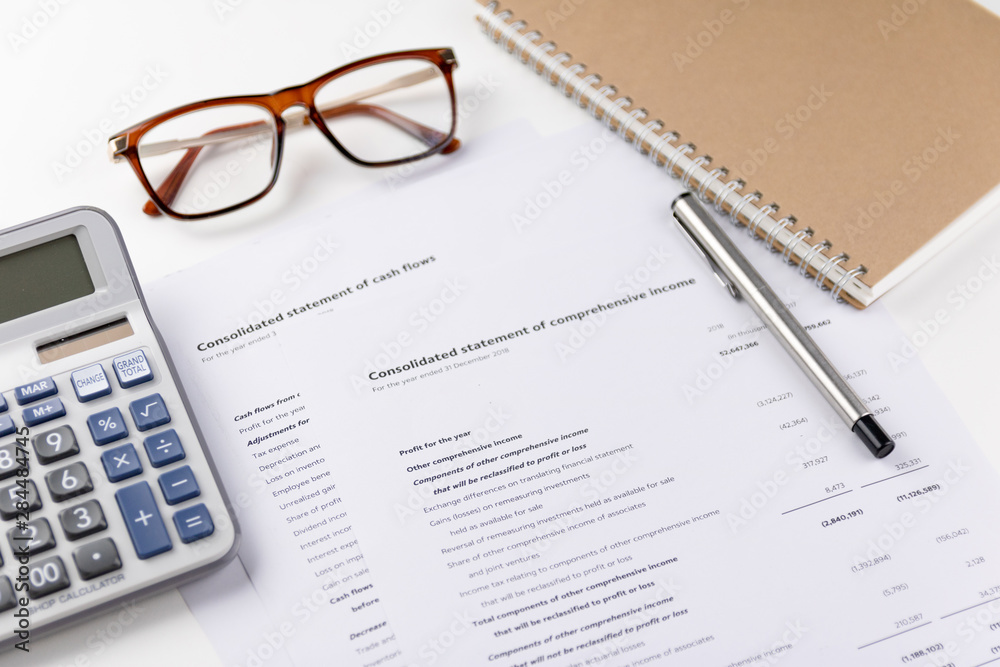Calculator, pen, notebook and financial report Put on the white table Calculator, pen, notebook and financial report Put on the white table