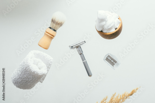 set for shaving with metal safe razor, wooden brush and soap.
