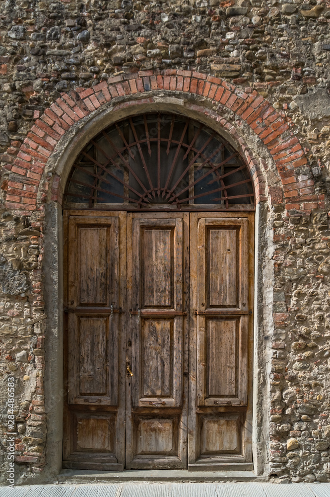 Arch doorway with old wooden door and stone wall Arch doorway with old wooden door and stone wall