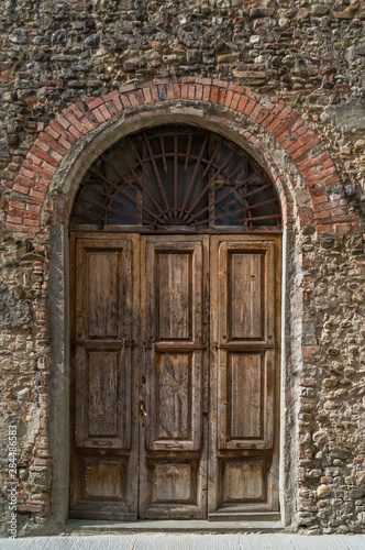 Arch doorway with old wooden door and stone wall