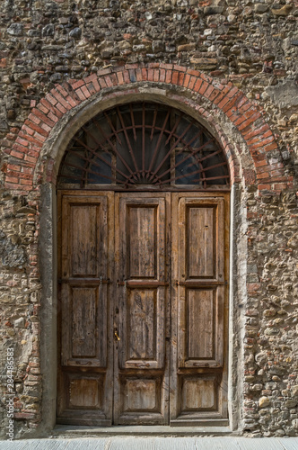 Arch doorway with old wooden door and stone wall
