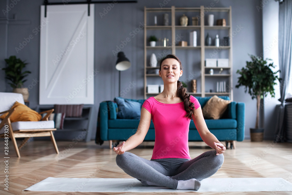 Yoga girl in lotus position in the living room. Yoga girl in lotus position in the living room.