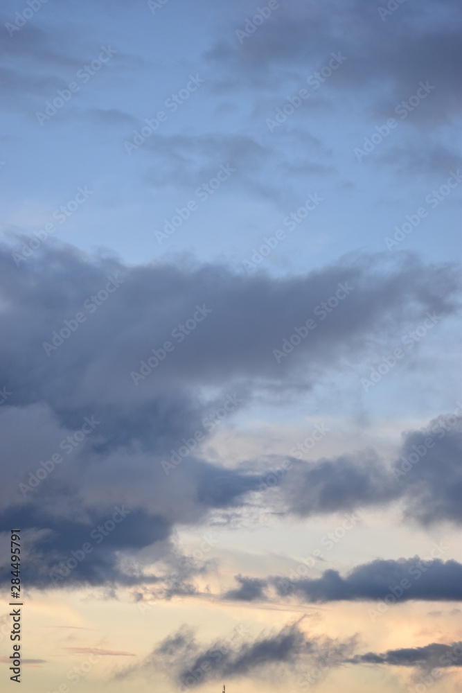 Clouds after rain in a light bluish and light yellowish sky