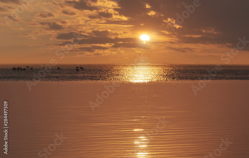 Bright sun and dramatic clouds over the atlantic ocean. Golden sunset in Africa