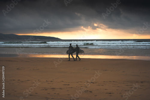 silhouette of surfers on the beach