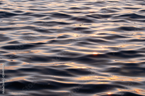 Close up picture of ocean waves at beach during sunset in Izmir in Turkey. Golden light on water.