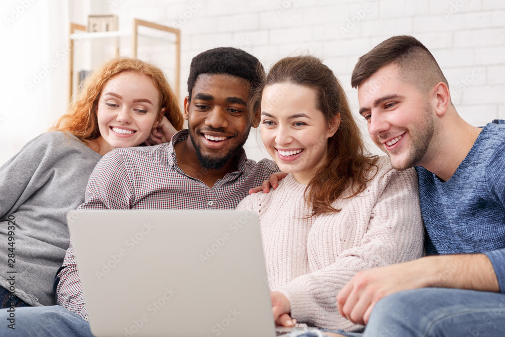 Friends sitting together and watching movie on laptop Friends sitting together and watching movie on laptop