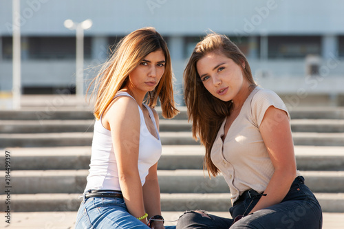 Beautiful girls in a city. Stylish ladies sitting on a stairs