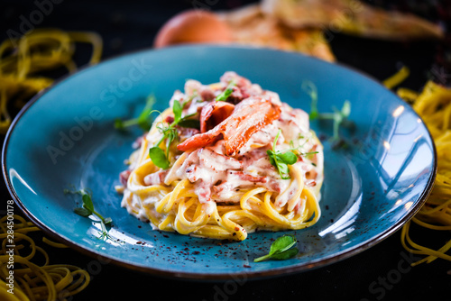 fresh italian spaghetti carbonara with tasty ingredients - cream, egg, bacon