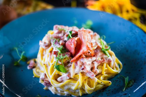 fresh italian spaghetti carbonara with tasty ingredients - cream, egg, bacon